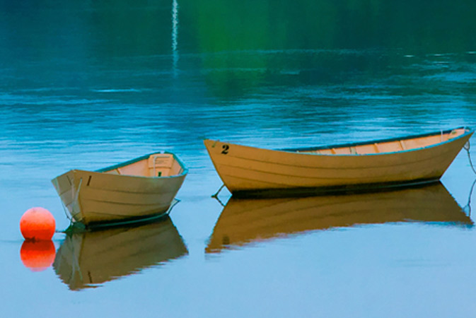 Two small boats anchored in water.